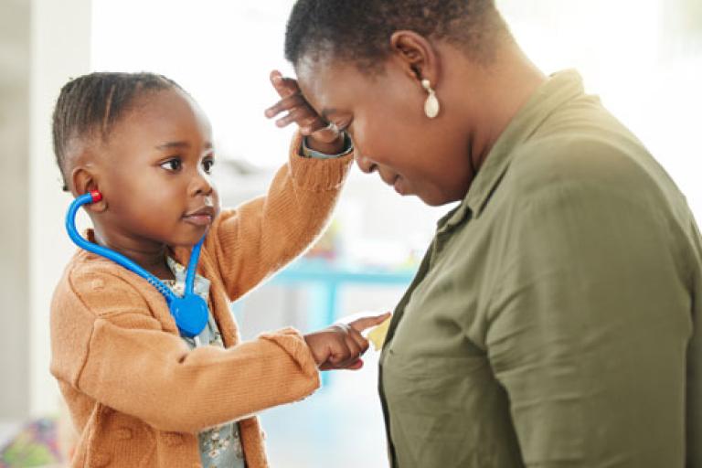 A toddler playing with his Mother, pretending to be a Doctor